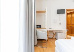 Doppelzimmer mit Tisch und Sessel und Doppelbett beim Urlaub mit Hund im Hotel Regina in Caorle