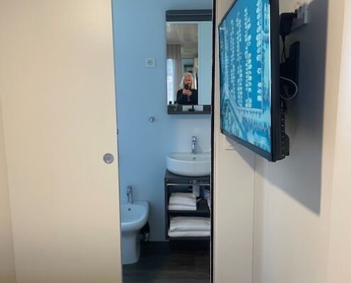 Blick vom Schlafzimmer ins Bad mit TV an der Wand Mobilheim Club del Sole Grado