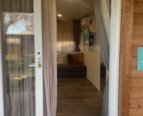 Einblick durch geöffnete Balkontür ins Mobilheim im Tenuta Primero Feriendorf Club del Sole in Grado